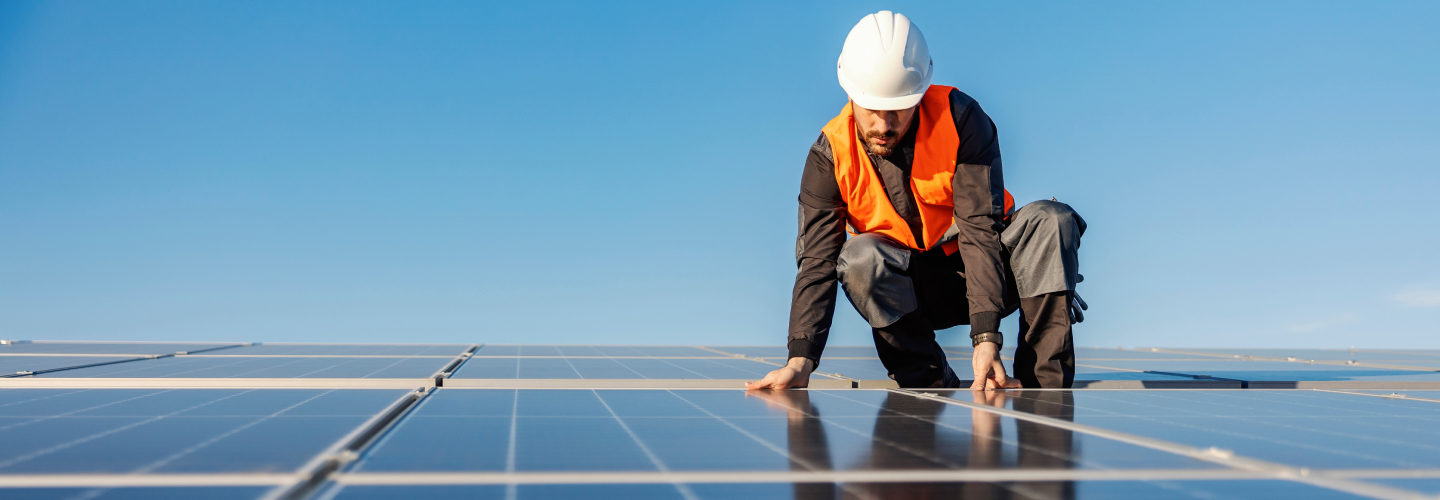 Solar technician installing panels on a rooftop under a clear blue sky, powered by Xero