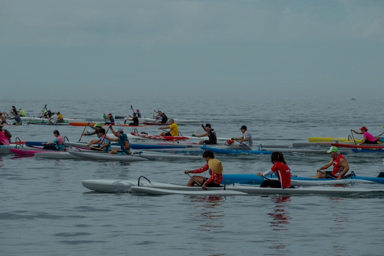 Group of paddlers racing in outrigger canoes on a calm ocean