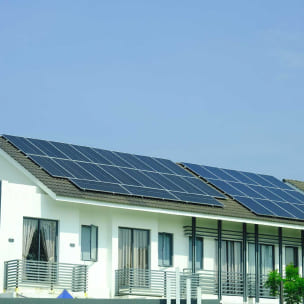 Residential home with rooftop solar panels installed on a red tile roof