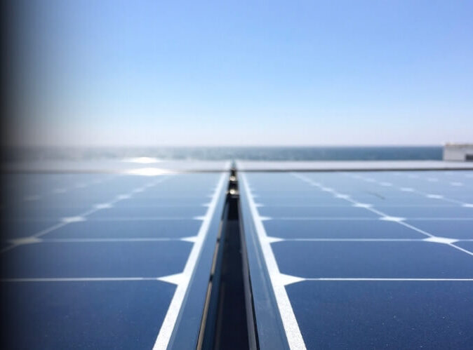 Close-up view of solar panels with an ocean backdrop