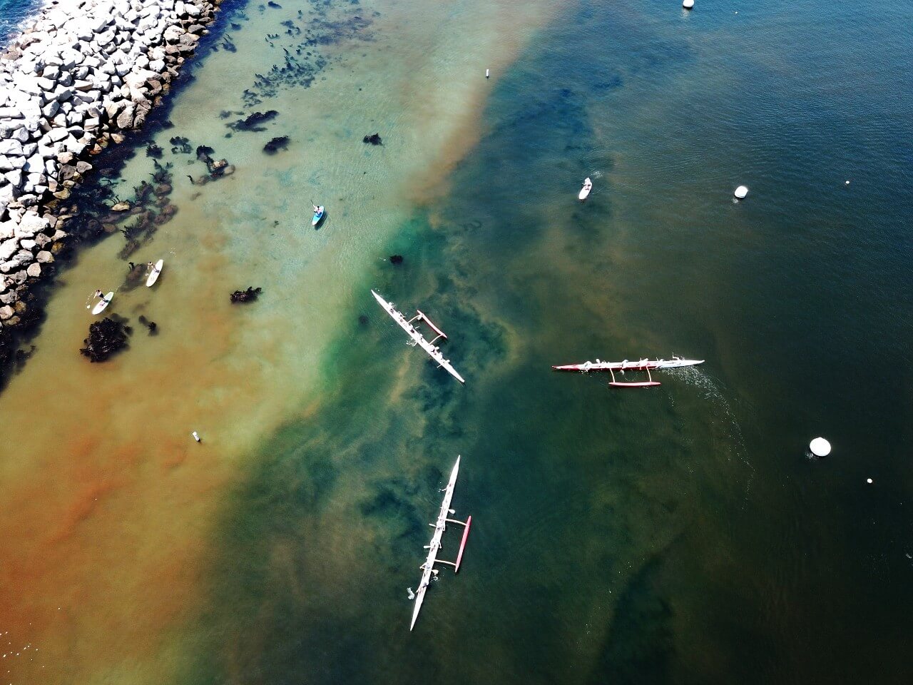 Aerial view of boats navigating near a rocky shoreline